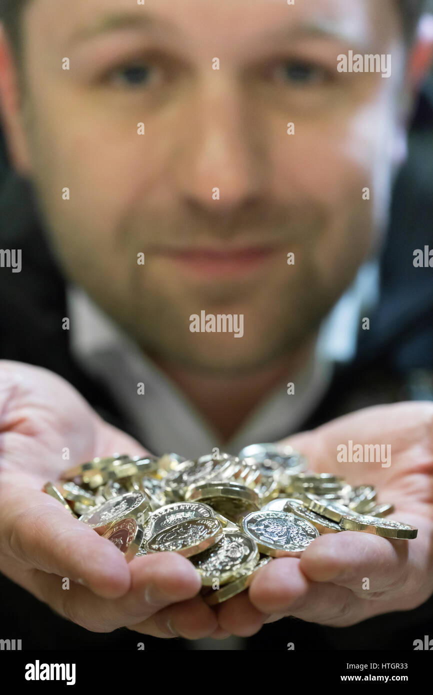 Llantrisant, nel Galles del Sud, Regno Unito. Il 14 marzo 2017. Scott Kuperus, 40, valuta la sicurezza e esperto tecnico presso il Royal Mint per 9 anni. Tenendo un lotto di appena premuto £1 monete. Con le elevate funzionalità di protezione della moneta, una tecnologia che è stata solo utilizzato in precedenza per le banconote, Scott Kuperus è fiducioso che il nuovo £ 1 è 'l'ost moneta sicura mai.' © Guy Corbishley/Alamy Live News Foto Stock