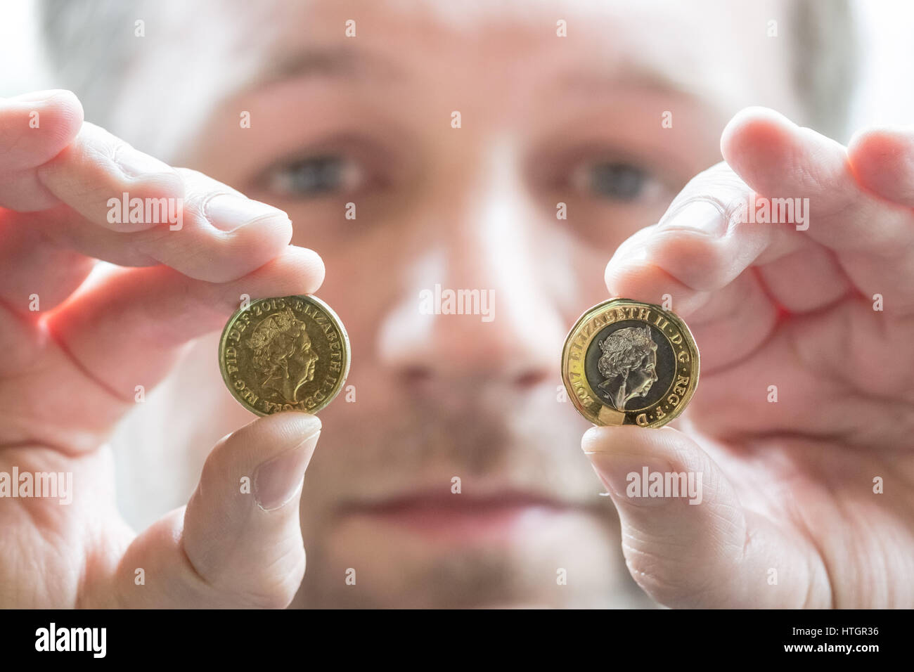 Llantrisant, nel Galles del Sud, Regno Unito. Il 14 marzo 2017. Scott Kuperus, 40, valuta la sicurezza e esperto tecnico presso il Royal Mint per 9 anni. Confrontare un poco pressato £1 moneta (R) che entrerà in circolazione il 28 marzo per sostituire il vecchio £1 moneta (L). Con le elevate funzionalità di protezione della moneta, una tecnologia che è stata solo utilizzato in precedenza per le banconote, Scott Kuperus è fiducioso che il nuovo £ 1 è 'l'ost moneta sicura mai.' © Guy Corbishley/Alamy Live News Foto Stock
