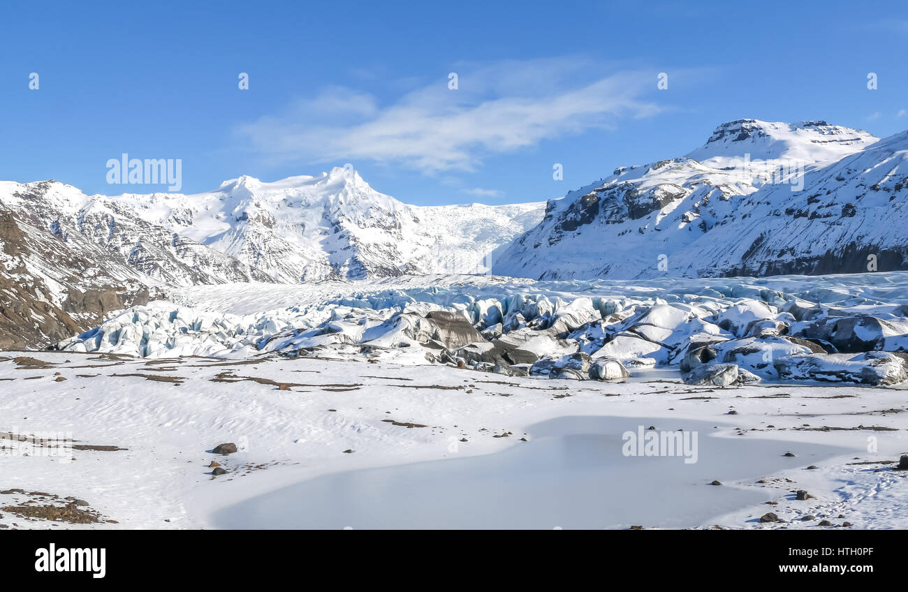 Coperta di neve Svínafellsjökull lingua del ghiacciaio Vatnajokull, Skaftatell National Park, Islanda, in inverno con cielo blu Foto Stock