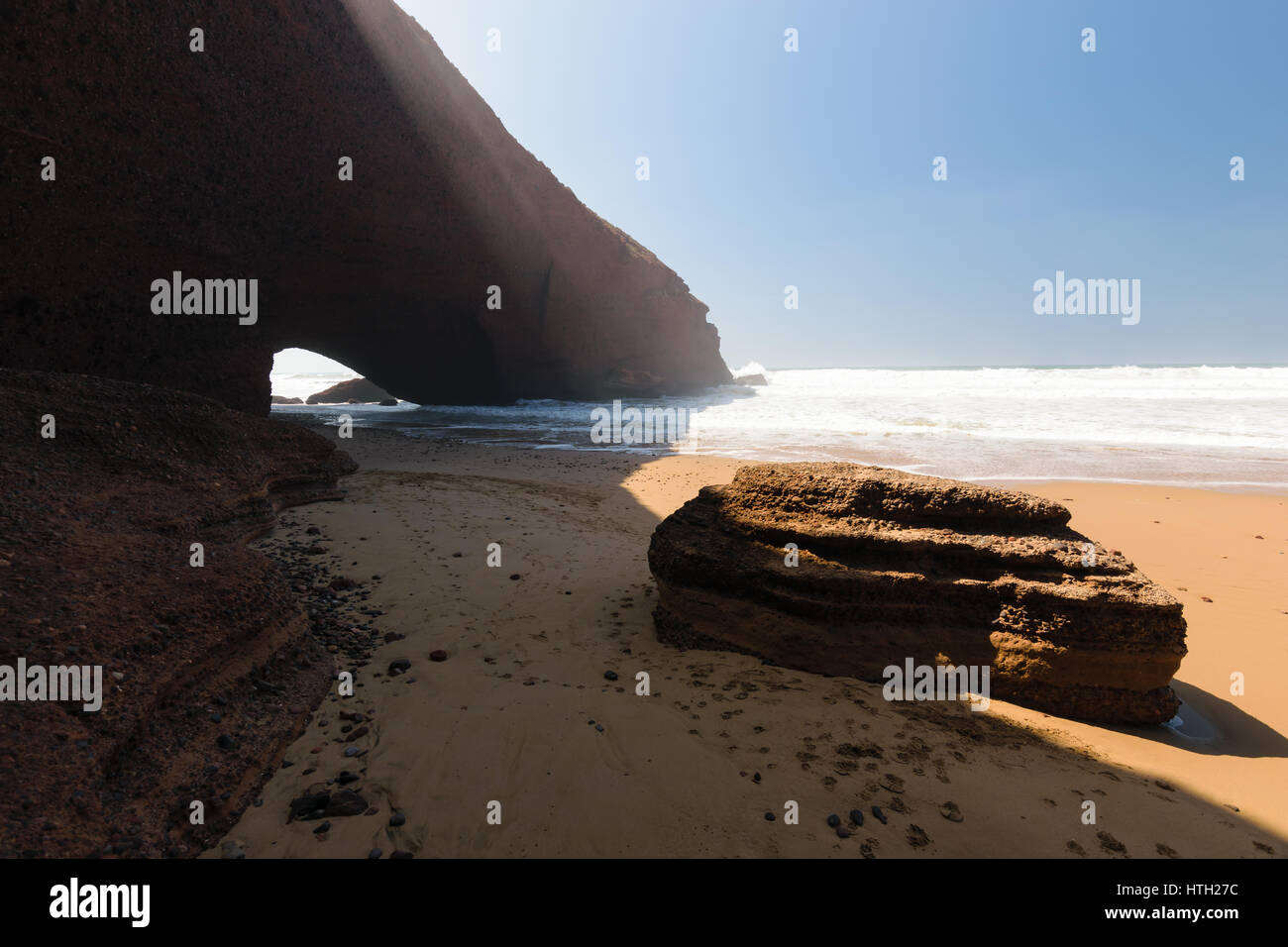 Archi in rosso e la spiaggia rocciosa e all'Oceano Atlantico nella regione Sous-Massa-Draa, Sidi Ifni, Legzira, Marocco, Africa. Foto Stock