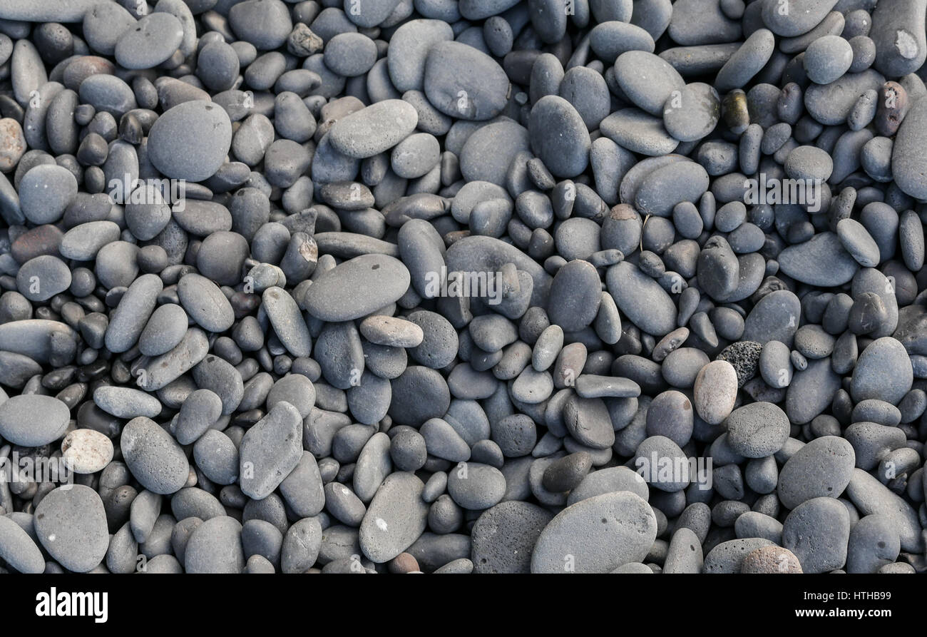 Levigato di lava nera ciottoli sulla spiaggia in Islanda per abstract naturale sfondo di ghiaia Foto Stock