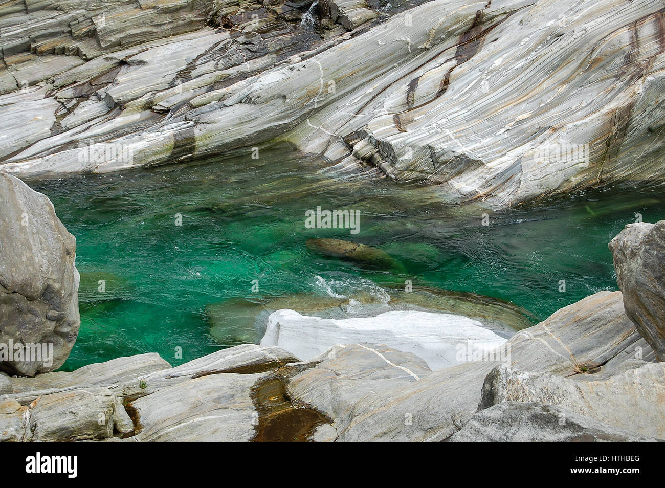 A scorrimento veloce a freddo acqua color smeraldo tra l'acqua-rocce levigate in Val Verzasca river in Svizzera Foto Stock