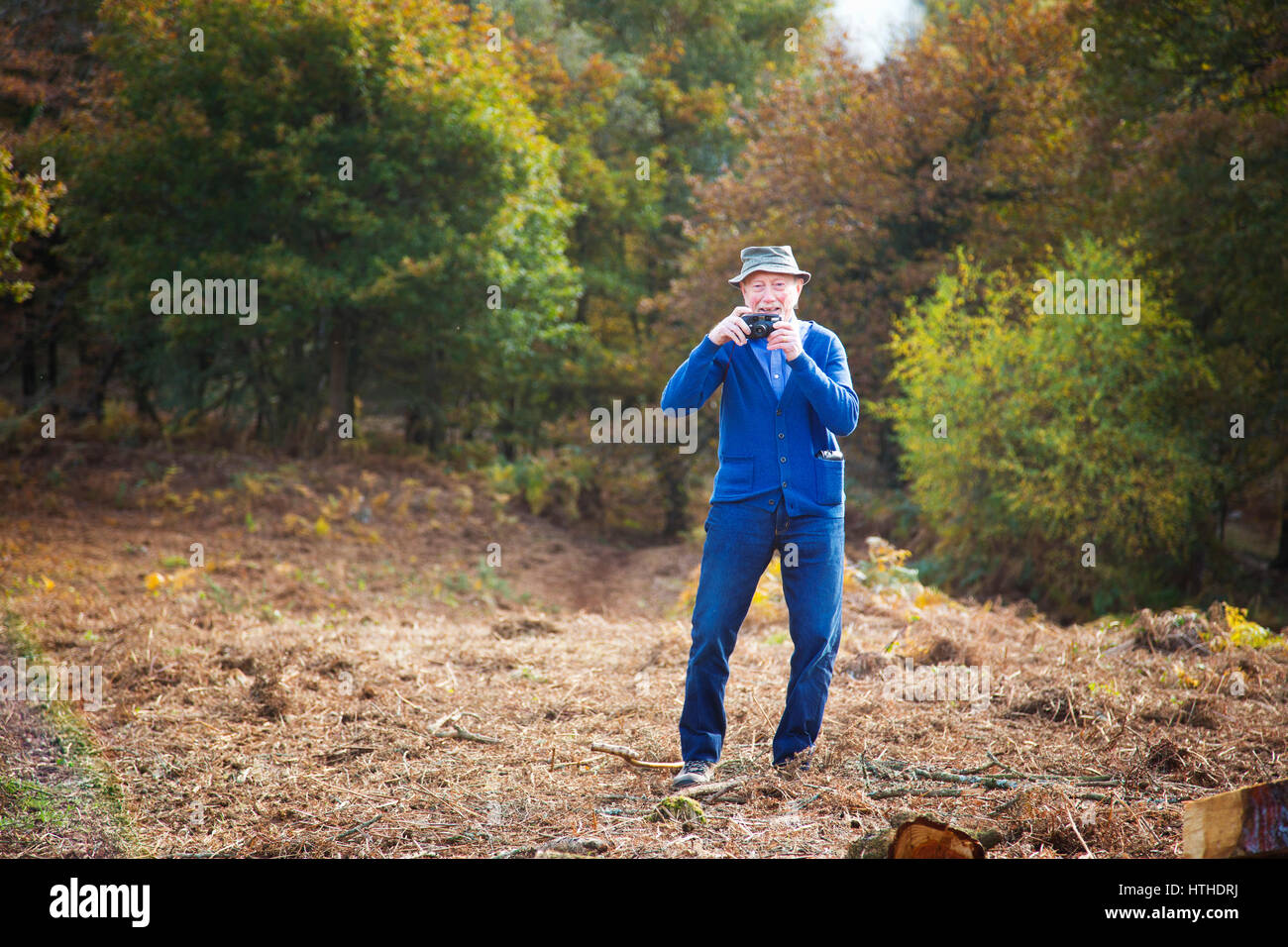 Un vecchio uomo di scattare una foto con la vecchia pellicola compatta fotocamera Foto Stock