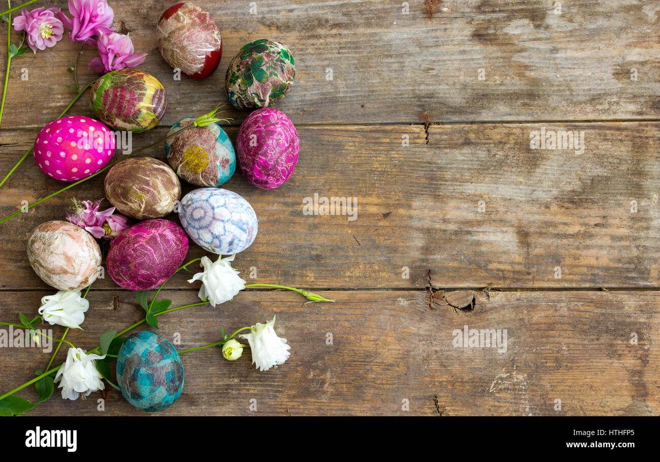 Gruppo di colorate uova di Pasqua decorate con fiori su sfondo di legno Foto Stock