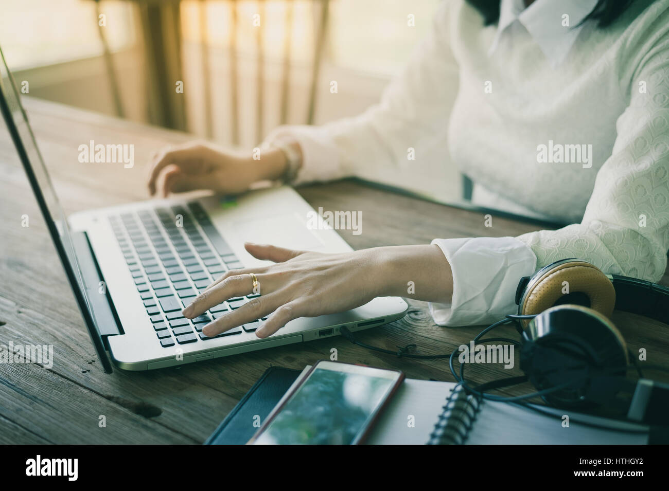 Donna mani digitando su laptop tastiera del computer mentre si lavora online con internet. Elaborato con vintage effetto filtro Foto Stock