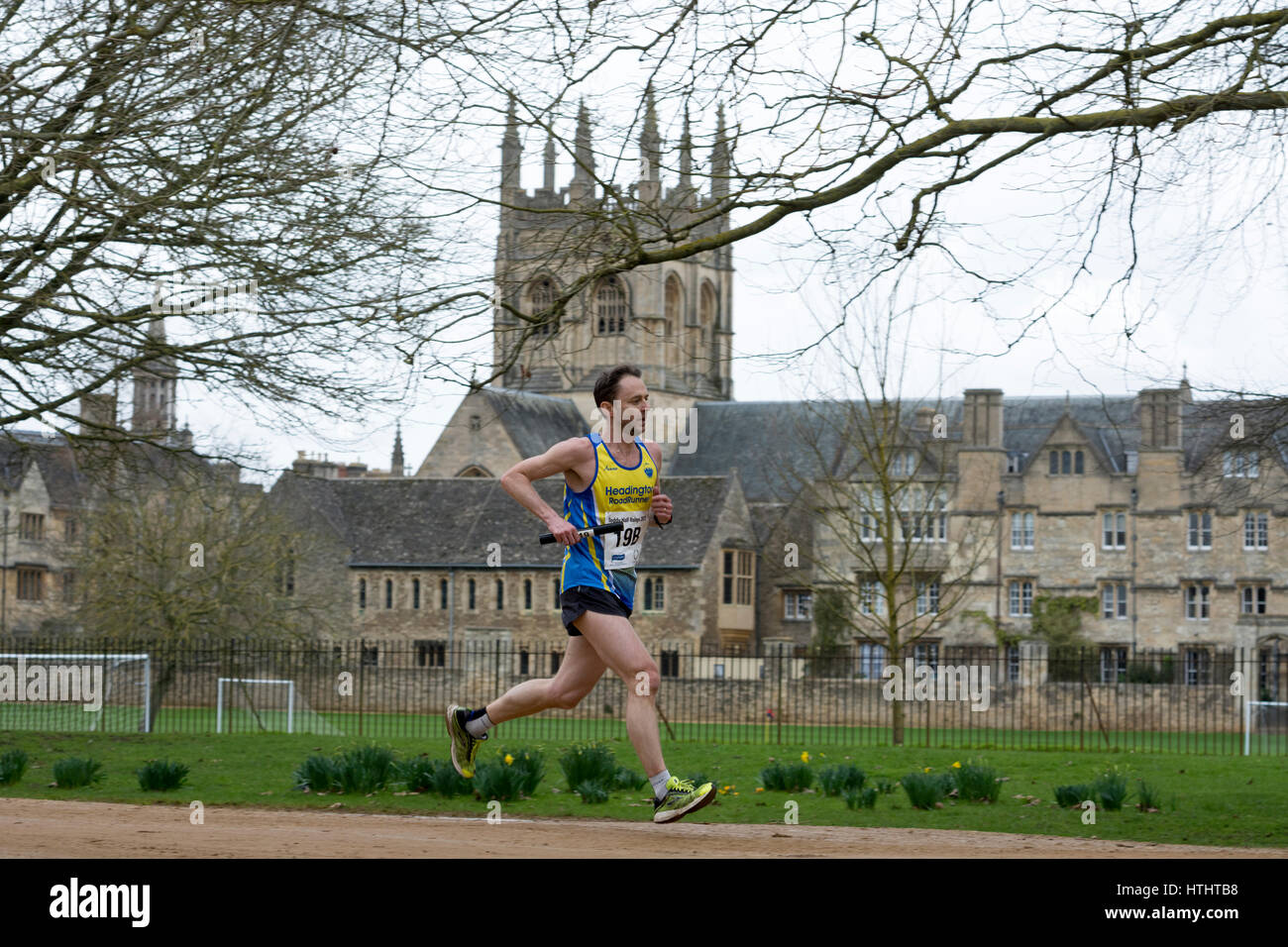 Un club runner passando Merton College Chapel in Teddy Hall relè, Oxford, Regno Unito Foto Stock