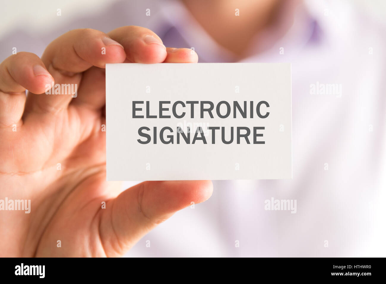 Primo piano su imprenditore tenendo una scheda con la firma elettronica del messaggio aziendale, concetto di immagine con messa a fuoco morbida dello sfondo Foto Stock