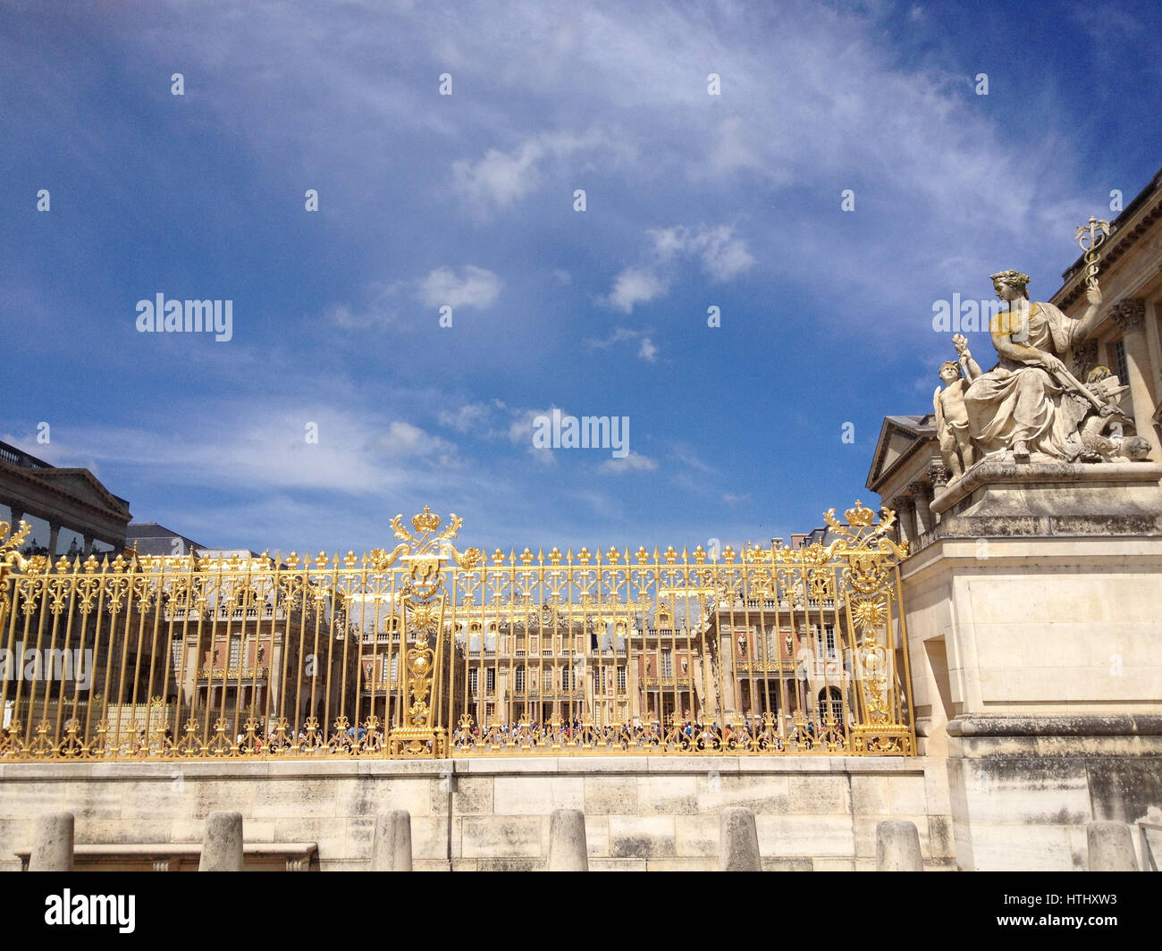 Oro cancelli di ingresso al Palazzo di Versailles nei pressi di Parigi, Francia.Deep Blue sky gate oro brilla al sole. Statua di Pietra della La Paix (Pace) b Foto Stock