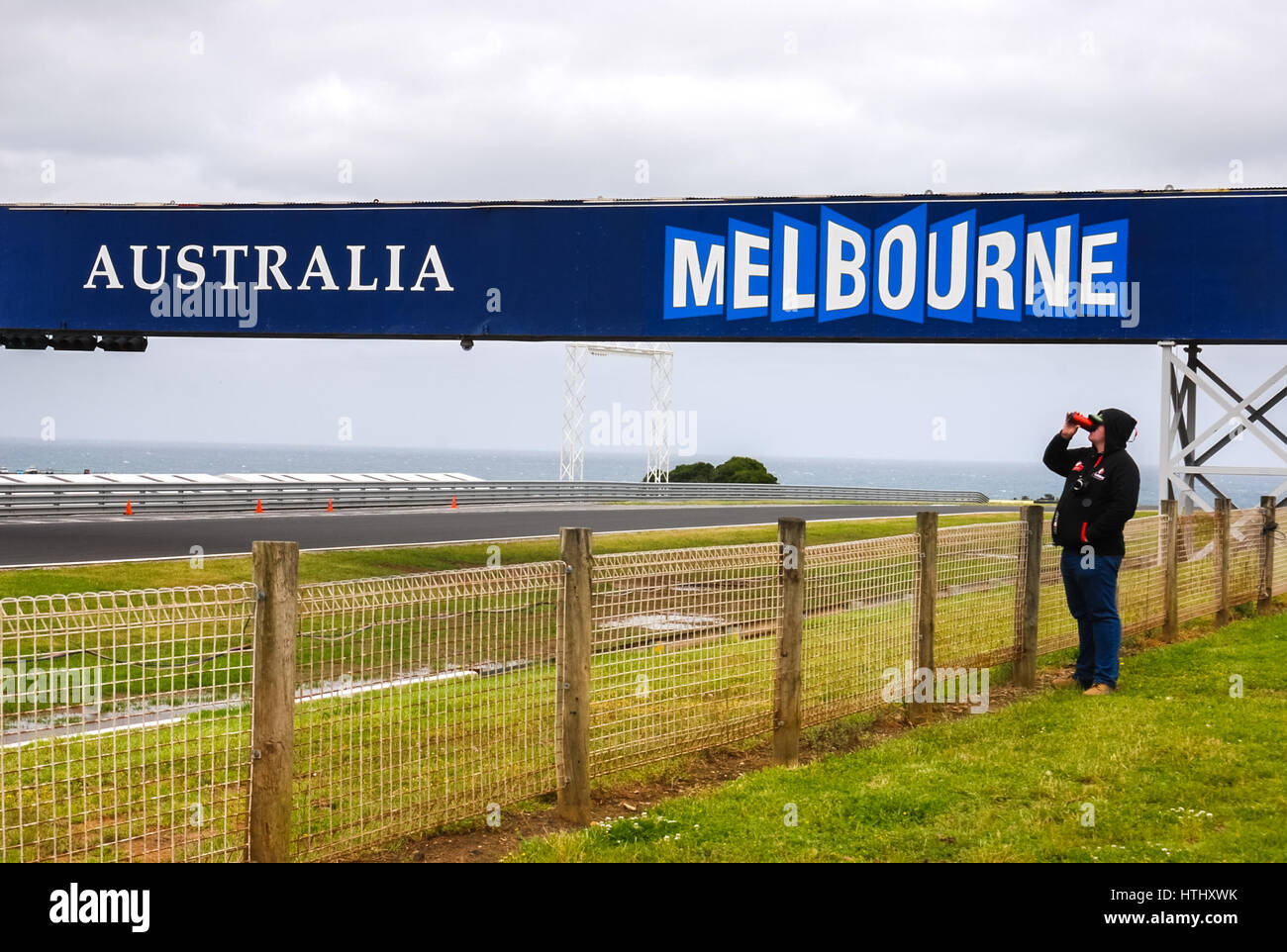 Un turista con un binocolo per vedere gli oggetti distanti in Phillip Island Grand Prix Circuit. Foto Stock