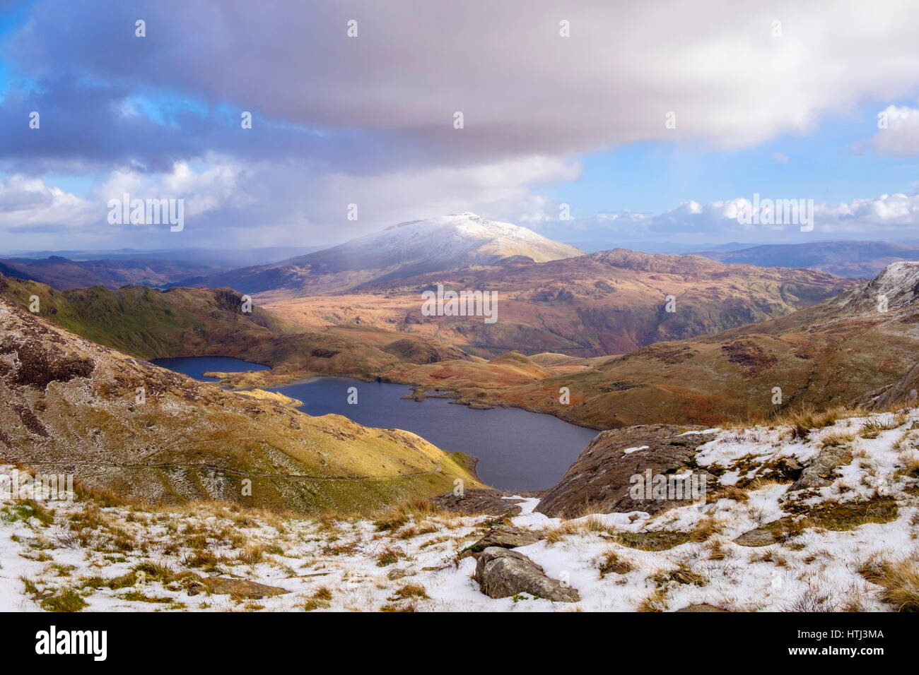 Vista di Llyn Llydaw lago e distante Moel Siabod da Y Gribin ridge in Snowdon a ferro di cavallo con la neve in inverno. Pen-y-Pass Snowdonia North Wales UK Foto Stock
