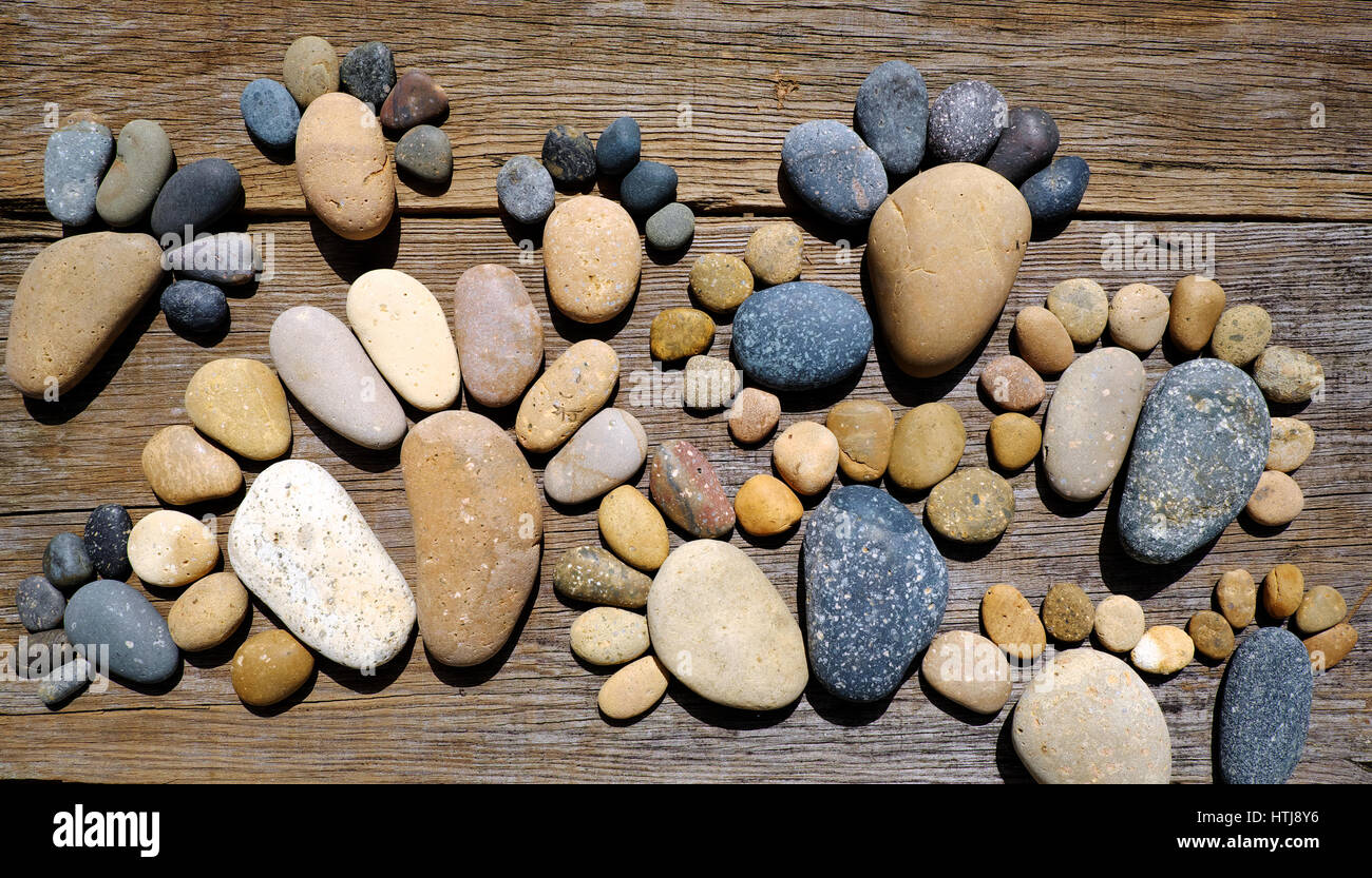 Abstract carino concetto su uno sfondo di legno da ciottoli, incredibile disposti boulder alla famiglia di footprint, impressionante forma da pebblestone Foto Stock