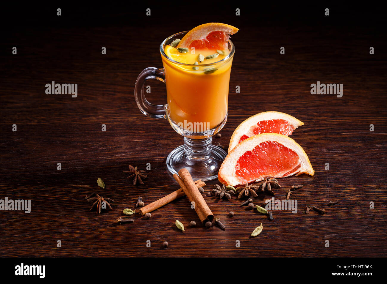 Bevanda di colore arancione. Pezzo di pompelmo e ghiaccio. Succo di frutta fresco e cannella. Rinfrescate la vostra estate. Foto Stock