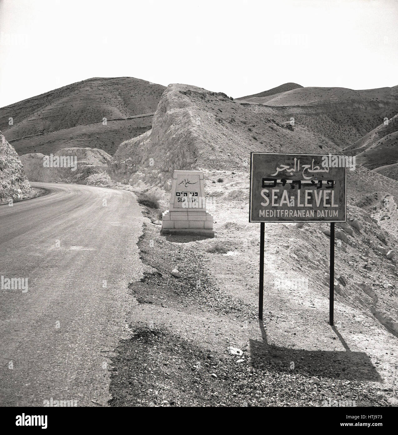 Degli anni Cinquanta, foto storiche che mostra due livello del mare segni accanto a una strada di montagna, Giordania. Foto Stock