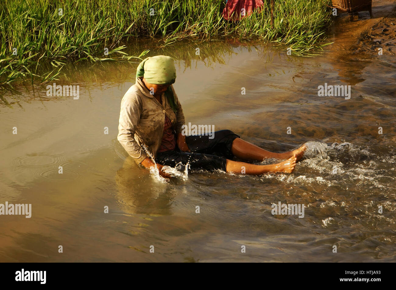 DAKLAK, VIET NAM- Settembre 5, 2012: donna vietnamita lavaggio in acqua al flusso della natura, questo è lo stile di vita della gente povera in Vietnam campagna, ella vasca da bagno Foto Stock