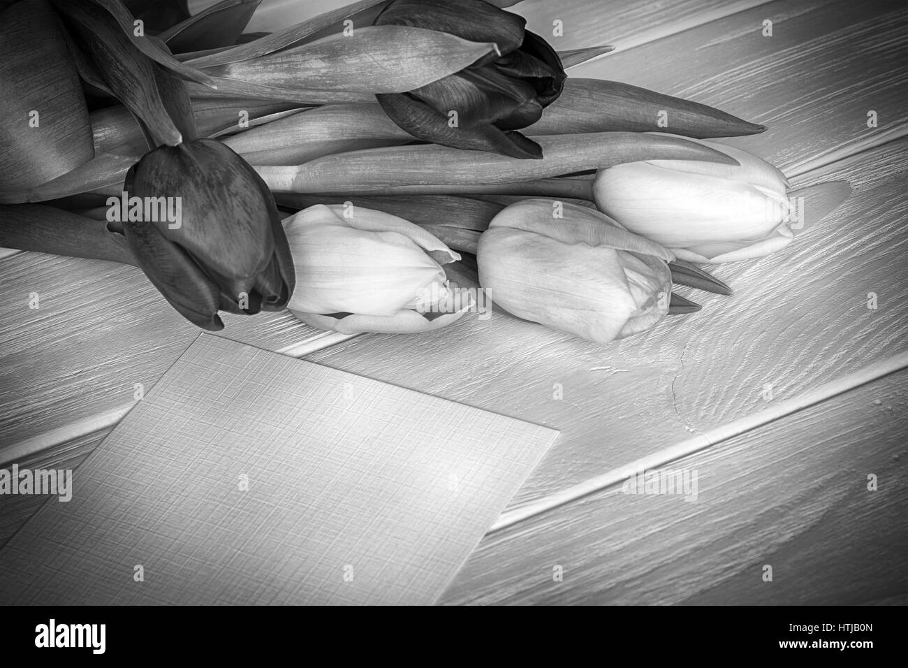 I tulipani bouquet e biglietto di auguri su sfondo di legno Foto Stock