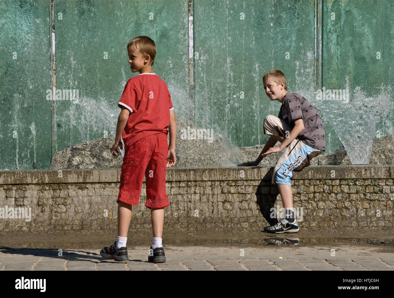 Due da fastidio a giocare con getti d'acqua a Rynek Fontana, costruito 1996, progettato da Alojzy Gryt, a Rynek (Piazza del Mercato) a Wroclaw, Bassa Slesia, Polonia Foto Stock