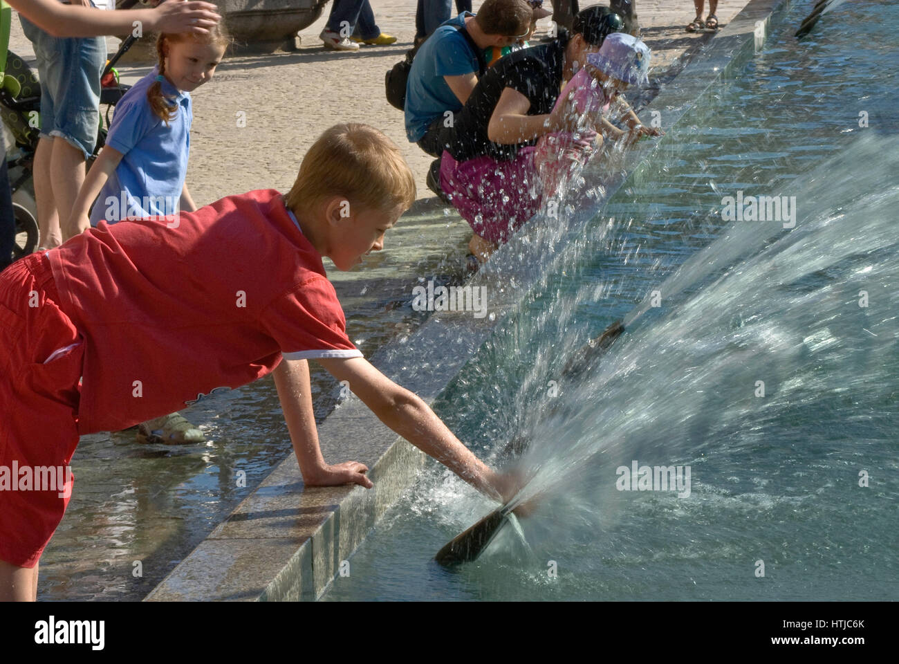 Ragazzo giocando con acqua a Rynek Fontana, costruito 1996, progettato da Alojzy Gryt, a Rynek (Piazza del Mercato) a Wroclaw, Bassa Slesia, Polonia Foto Stock