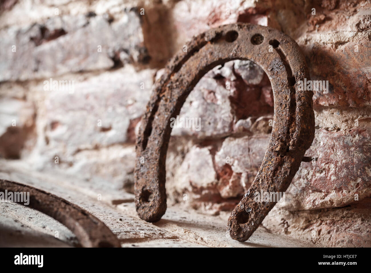Vecchio arrugginito sorge a ferro di cavallo vicino a un muro di mattoni, vicino la foto con il fuoco selettivo Foto Stock