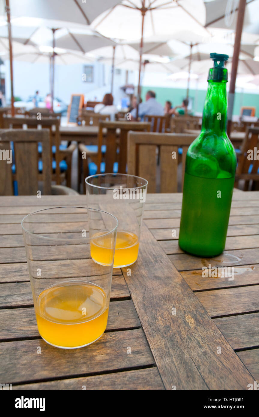 Due bicchieri e una bottiglia di sidro. Cudillero, Asturias, Spagna. Foto Stock
