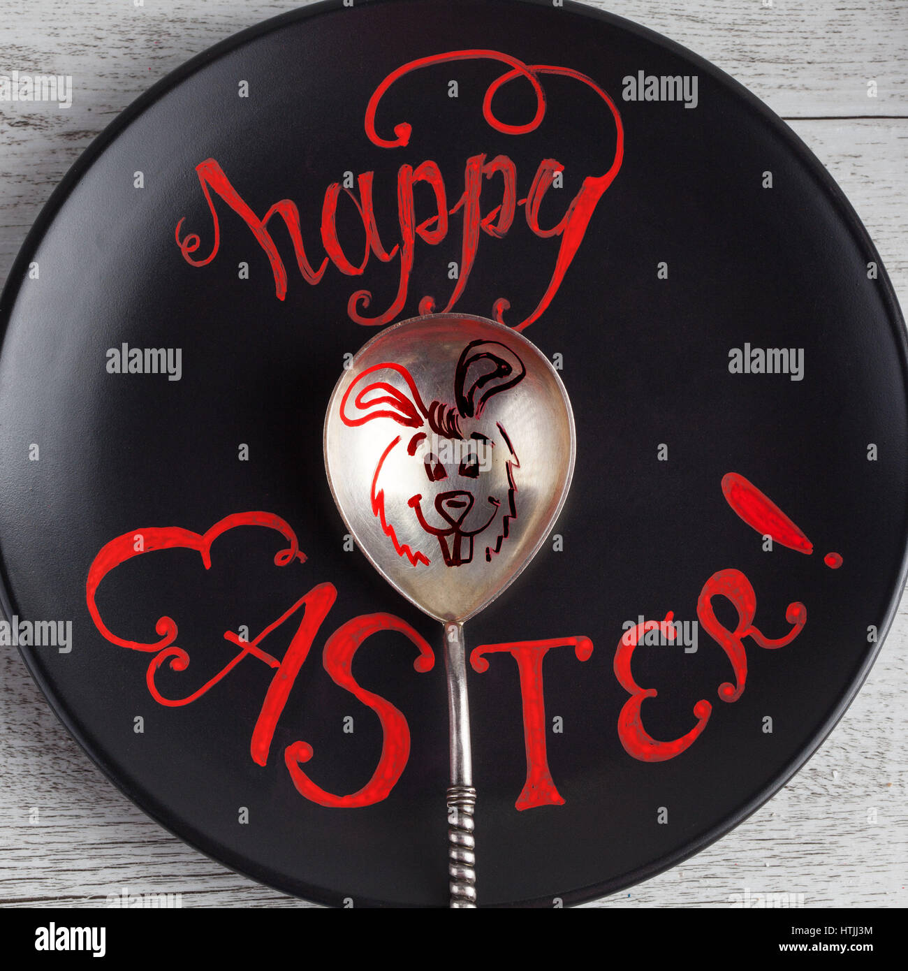 Felice Pasqua scritte a mano il preventivo scritto su piastra nera con il coniglietto di pasqua disegno su vintage cucchiaio d'argento. Immagine quadrata Foto Stock