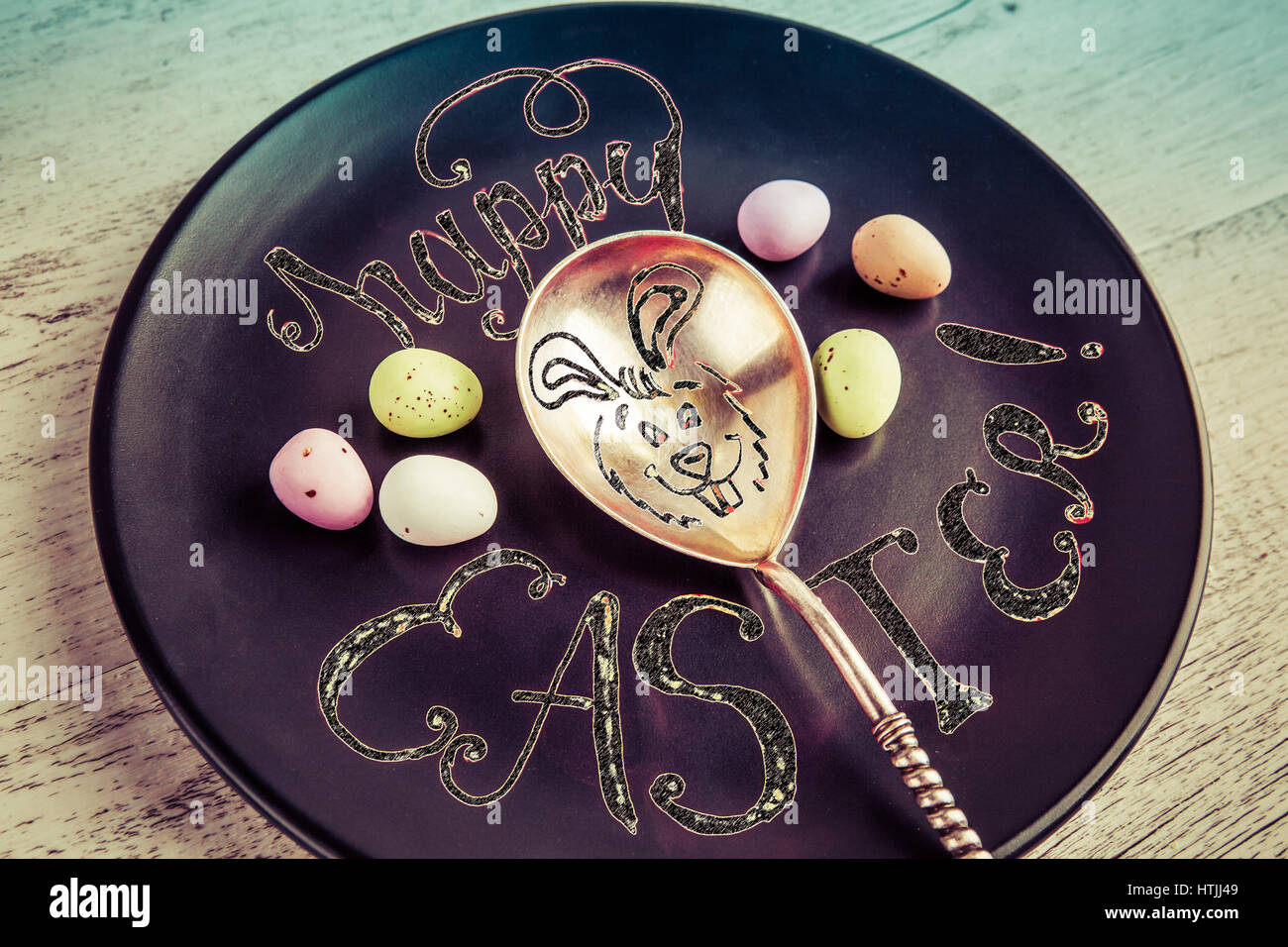 Felice Pasqua scritte a mano preventivo con il coniglietto di pasqua disegno su vintage cucchiaio d'argento. Decorate con le uova di Pasqua di cioccolata con filtro retrò Foto Stock