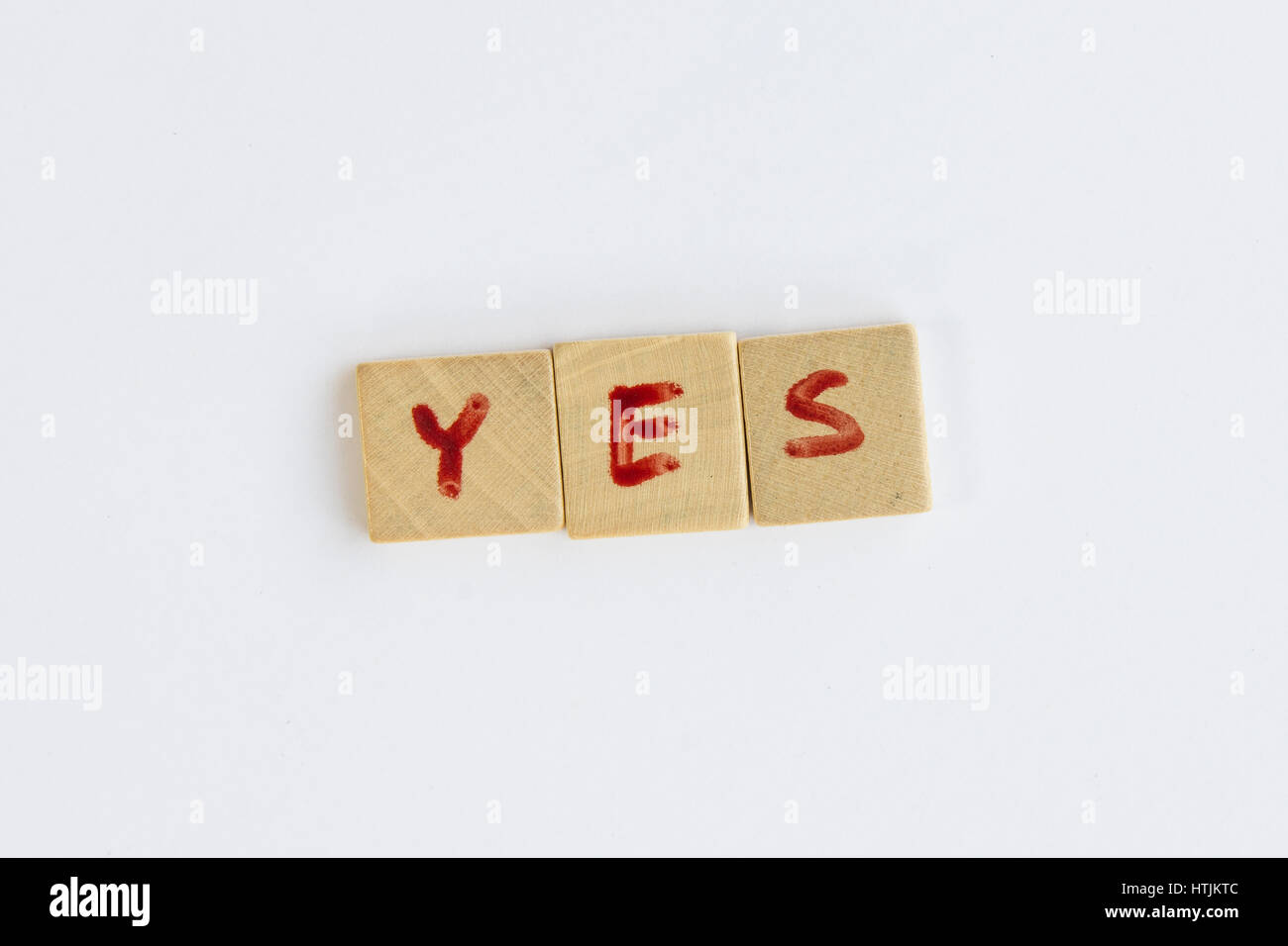 La parola sì formato con lettere scritte sulle piazze di tasselli di legno Foto Stock