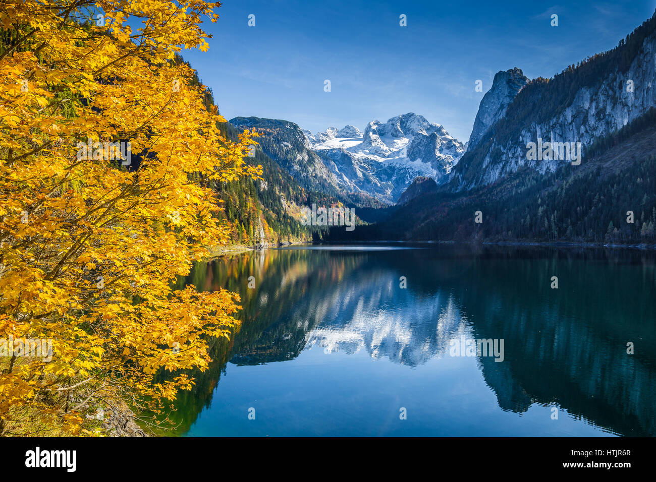 Bellissima vista idilliaca colorato paesaggio autunnale con Dachstein mountain summit riflettendo in crystal clear Gosausee lago di montagna nella caduta, Austria Foto Stock