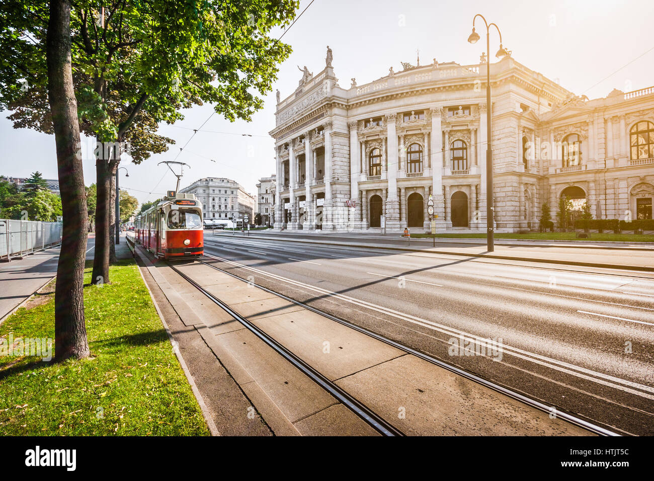 Celebre Wiener Ringstrasse con Burgtheater storico (Imperial Court Theatre) e tradizionale rosso tram elettrico a sunrise di Vienna in Austria Foto Stock