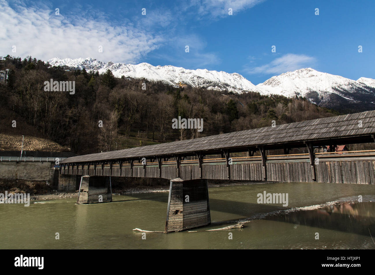Passerella Coperta ponte che attraversa il fiume Inn a Innsbruck in Austria, con montagne delle Alpi austriache in background. Foto Stock
