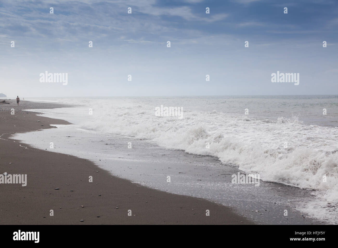 Mare con spiaggia di sabbia, onde e cielo Foto Stock
