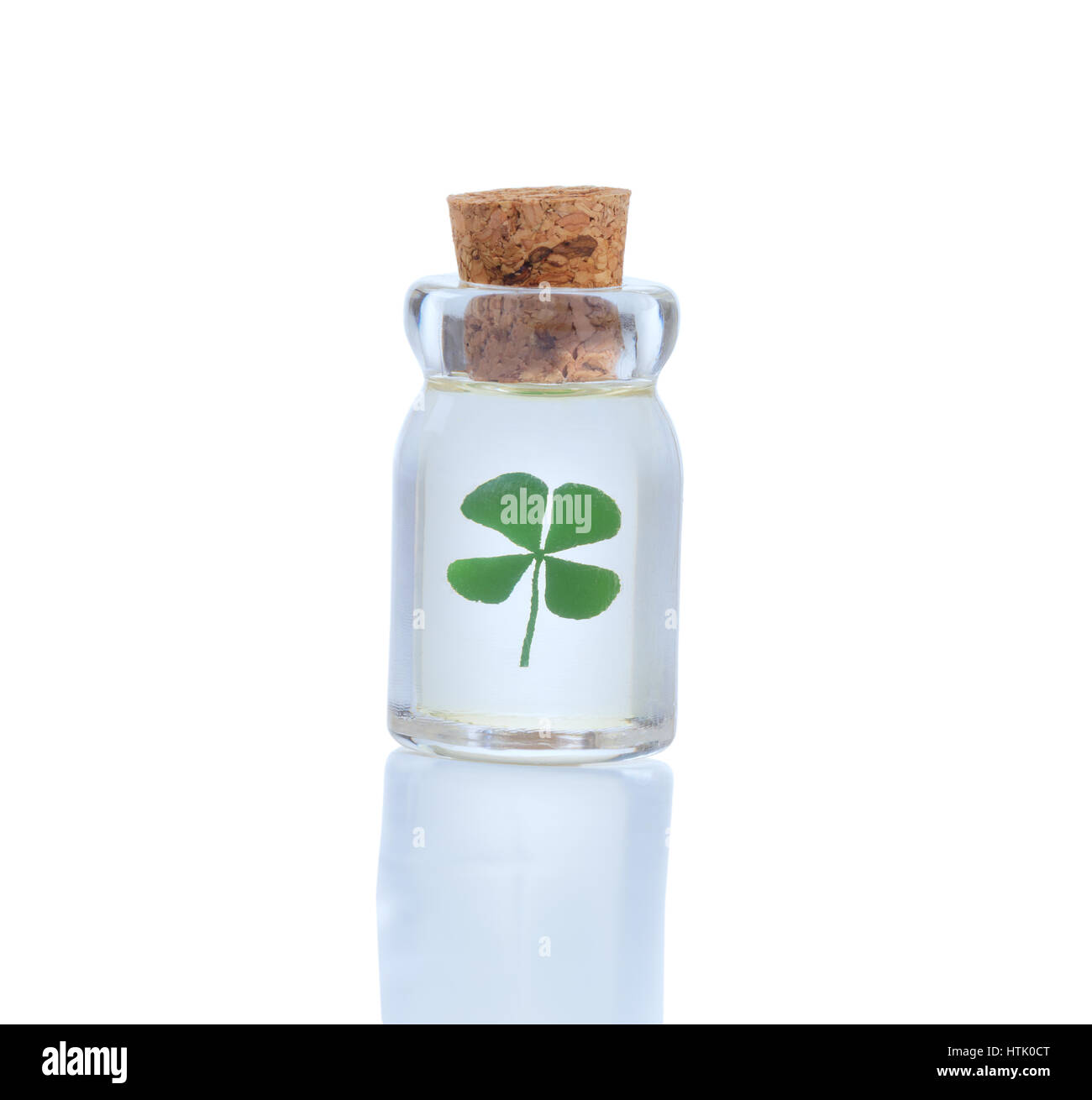 Sigillato bottiglia di vetro tenendo solo quattro leaf clover isolato su bianco con la riflessione. Fortuna nel concetto della bottiglia per la Festa di San Patrizio. Foto Stock