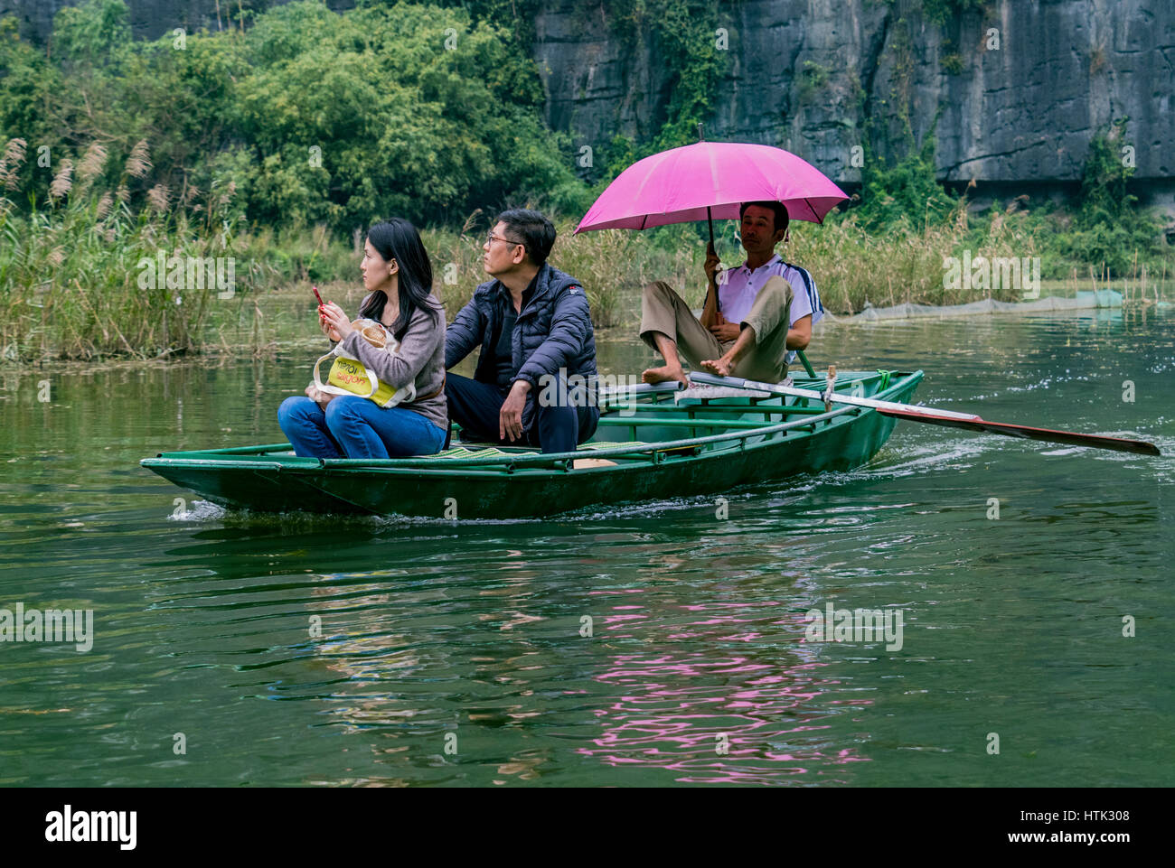 Barca a remi per viaggio turistico a Boi river Tam Coc Vietnam. La maggior parte dei regatanti in queste barche di utilizzare i loro piedi per fare canottaggio piuttosto che le loro mani. Foto Stock