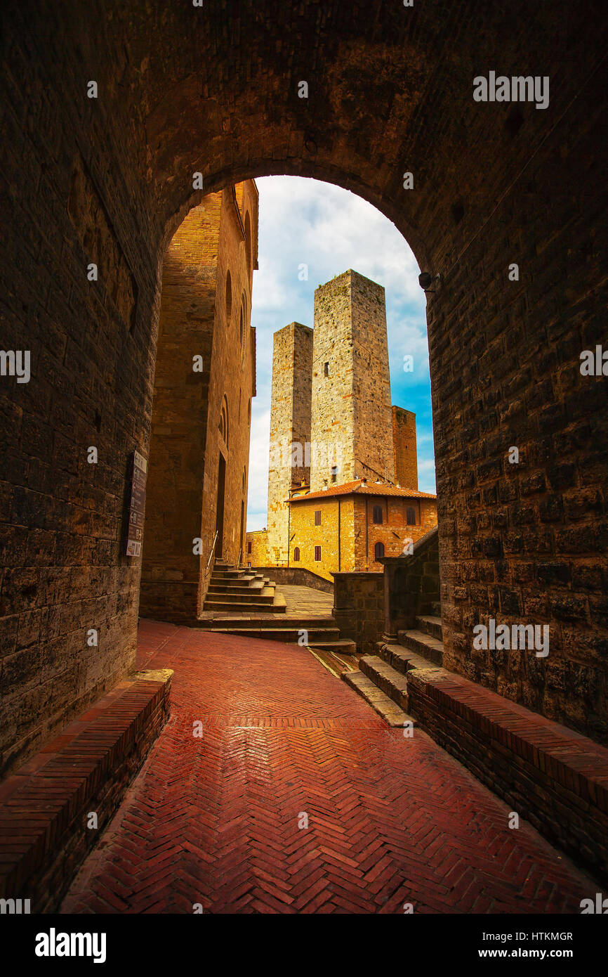 San Gimignano landmark città medievale. Tramonto da un tunnel su torri nella zona centrale di Piazza Erbe. Toscana, Italia, Europa. Foto Stock