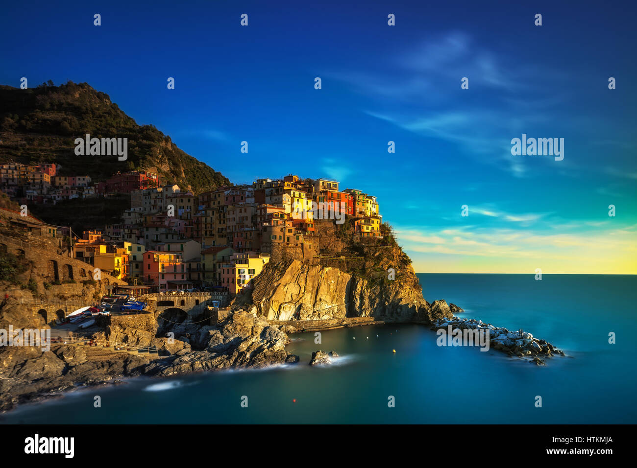 Manarola village sulla scogliera di rocce e mare al tramonto., Seascape in cinque terre, il Parco Nazionale delle Cinque Terre Liguria Italia Europa. Formato quadrato. Lunga Expo Foto Stock