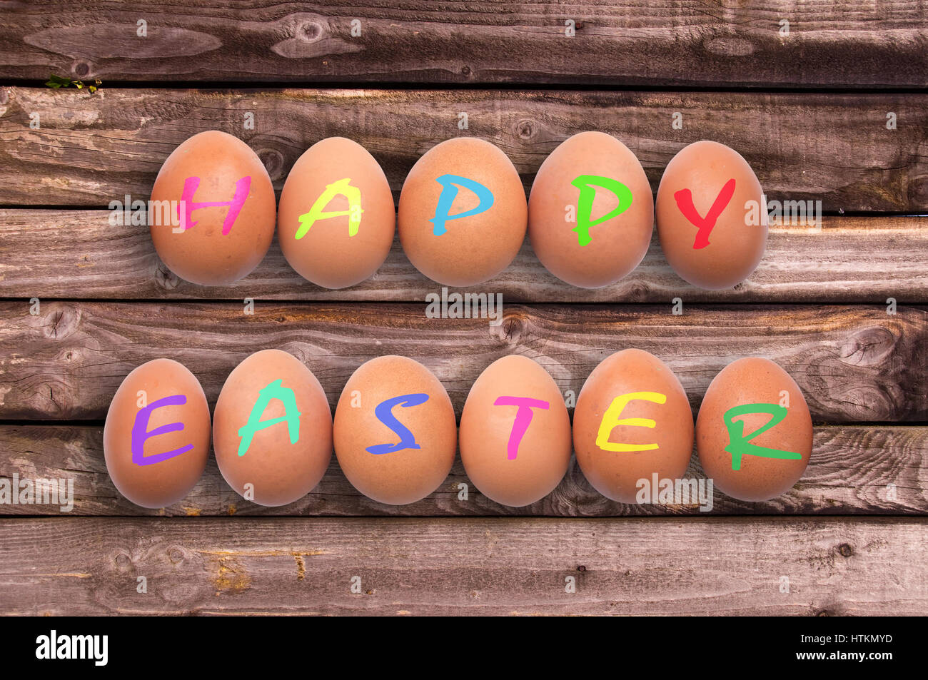 Felice Pasqua scritto su uova su tavole di legno sfondo Foto Stock