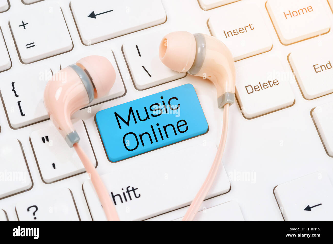 Musica online auricolari bianco sulla tastiera del computer. Foto Stock