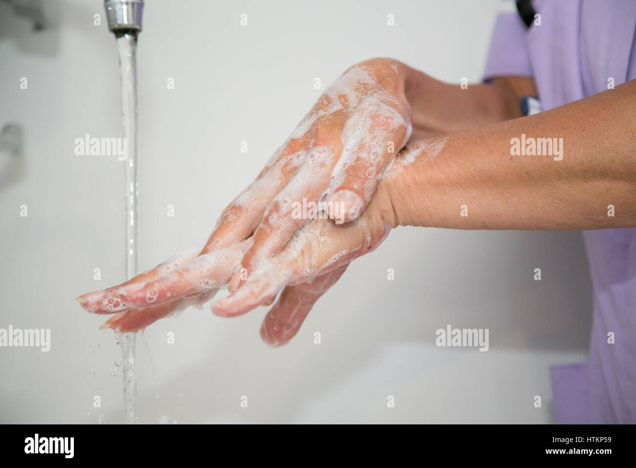 Lavarsi le mani con acqua e sapone in ambiente clinico Foto Stock