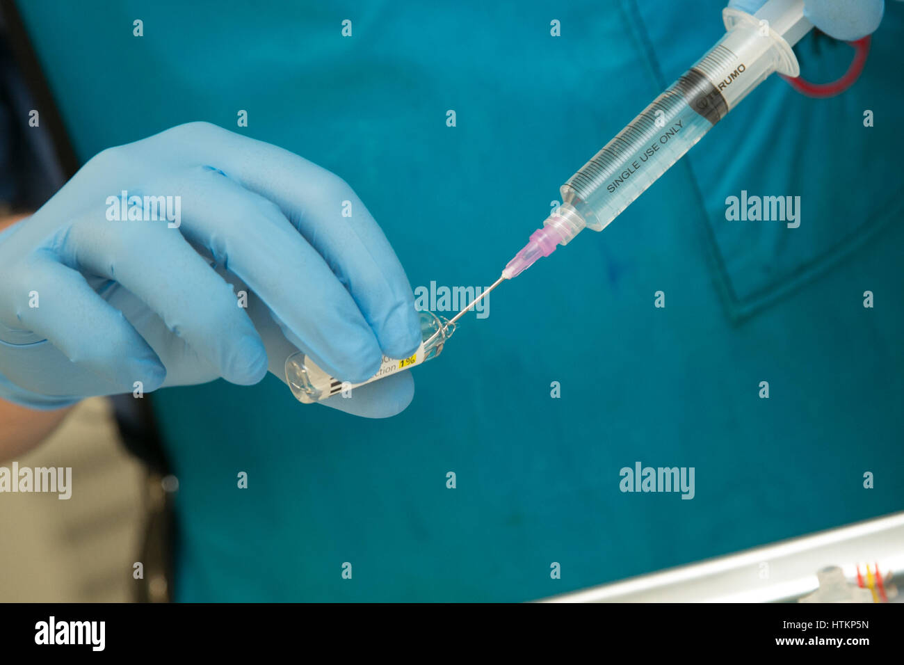 Elaborazione di una siringa in un ambiente clinico Foto Stock