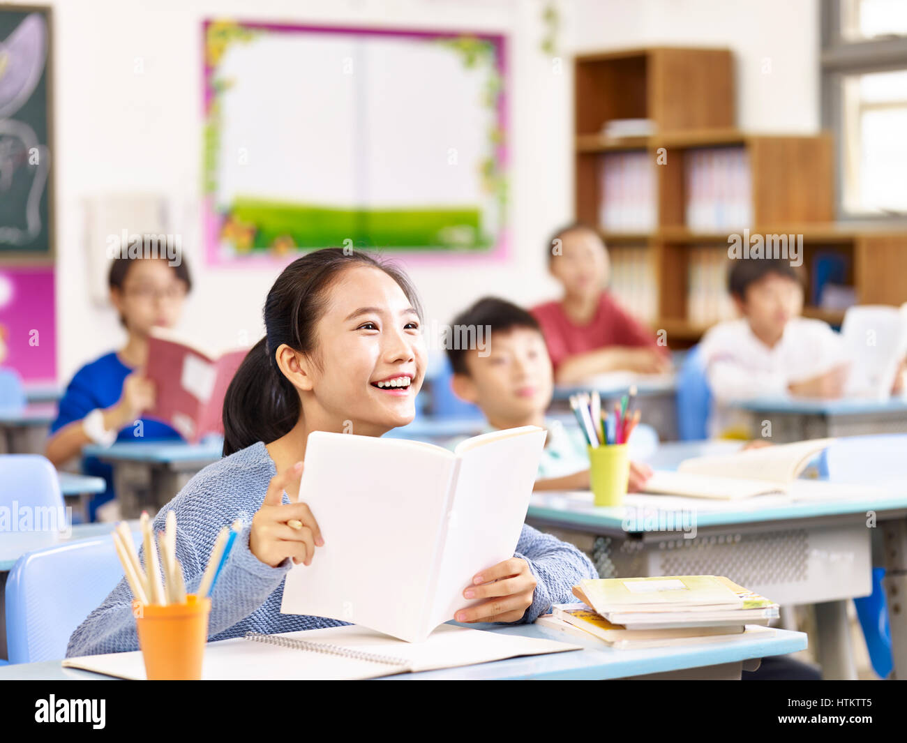 Asian scuola elementare studente sorridente in classe. Foto Stock