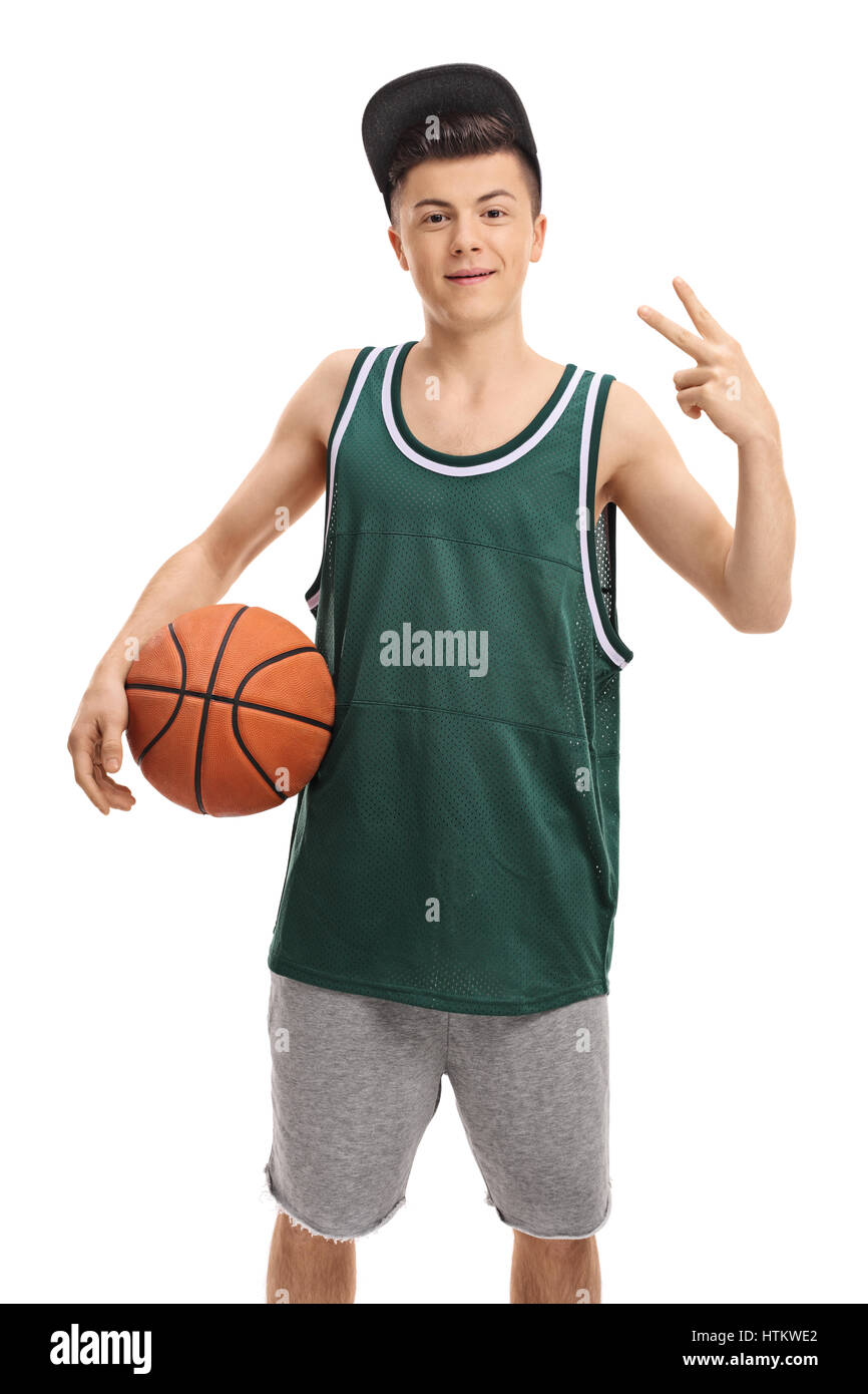 Adolescente in una maglia verde tenendo una palla da basket e facendo un gesto di vittoria isolati su sfondo bianco Foto Stock