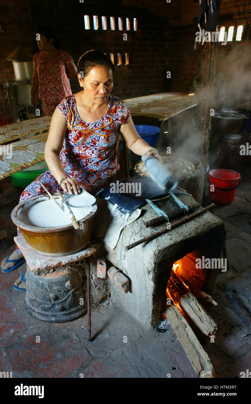 Ba Ria, Viet Nam, donna asiatica seduta di lavoro a casa, Vietnamita femmina di rendere la carta di riso da farina di riso a banh trang trade village, Vietnam Foto Stock