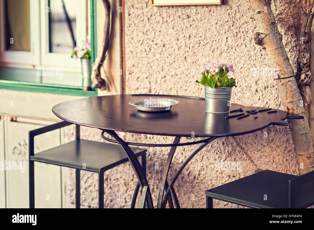 Vaso di primule in fiore su un tavolo esterno. Messa a fuoco selettiva. Foto in stile vintage Foto Stock