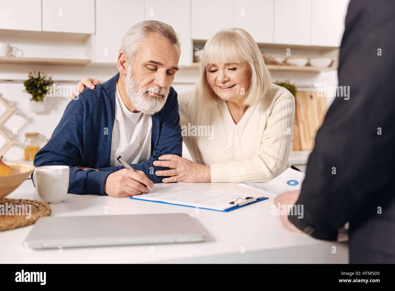 Una deliziosa coppia di anziani la firma dei documenti a casa Foto Stock