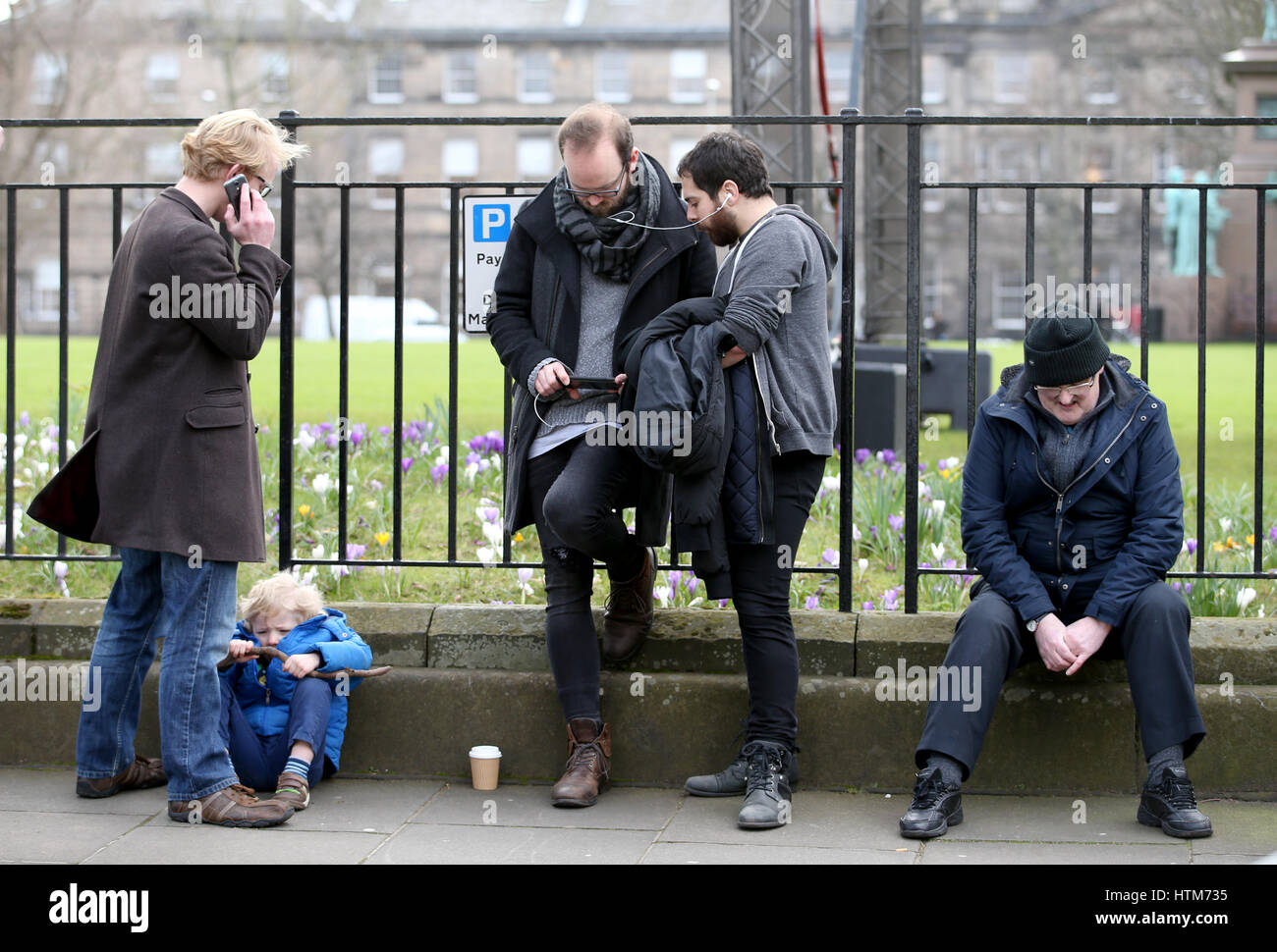 I membri del pubblico e ascoltano e guardano sugli smartphone un live-stream del primo ministro Nicola Sturgeon che tiene una conferenza stampa, a Charlotte Square, Edimburgo, dove ha detto che darà a Scots una "reale scelta" tra la Brexit e lasciare il Regno Unito in una seconda votazione sull'indipendenza. Foto Stock