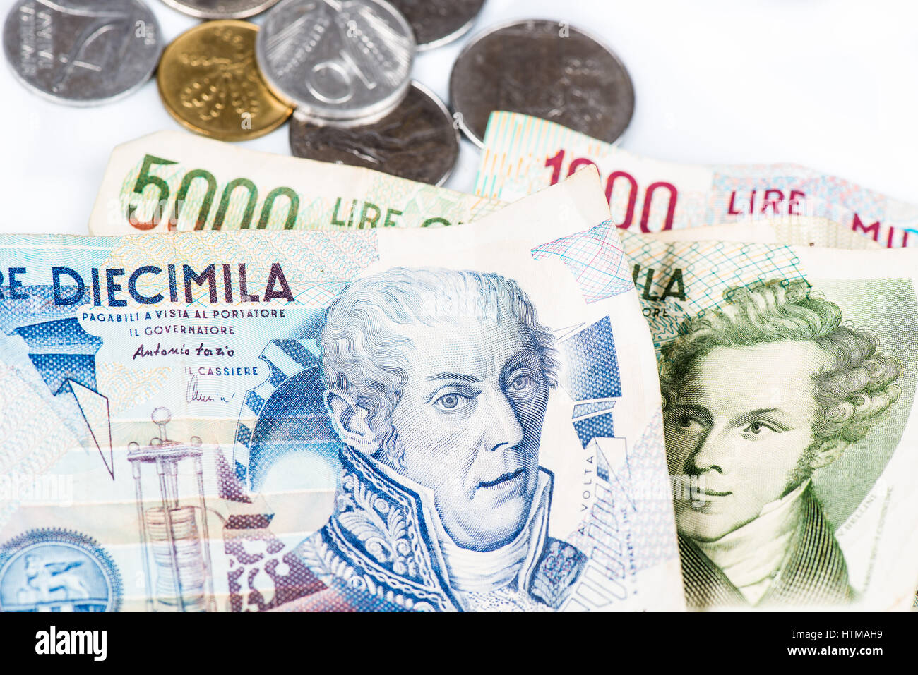 Banconote da Italia. Lira italiana e monete metalliche su sfondo bianco Foto Stock