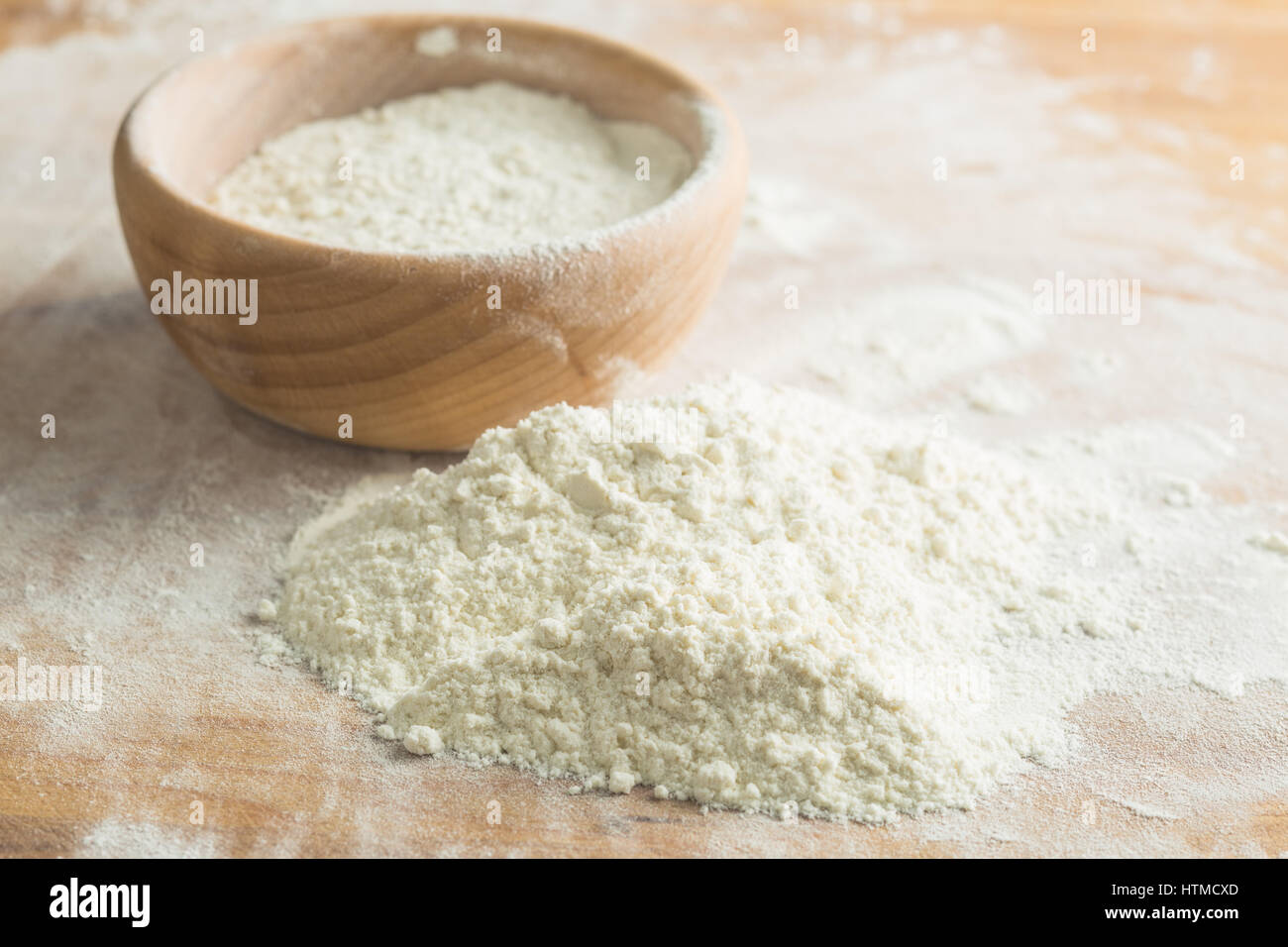 La farina di grano sul tavolo di legno con ciotola di legno. Foto Stock
