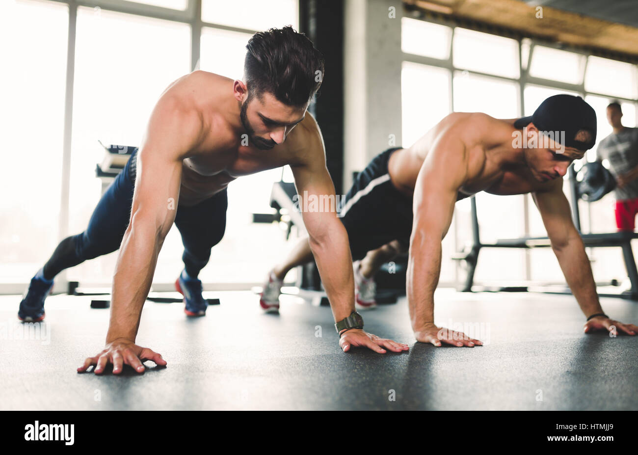 Persone che lavorano e facendo spingere ups in palestra Foto Stock