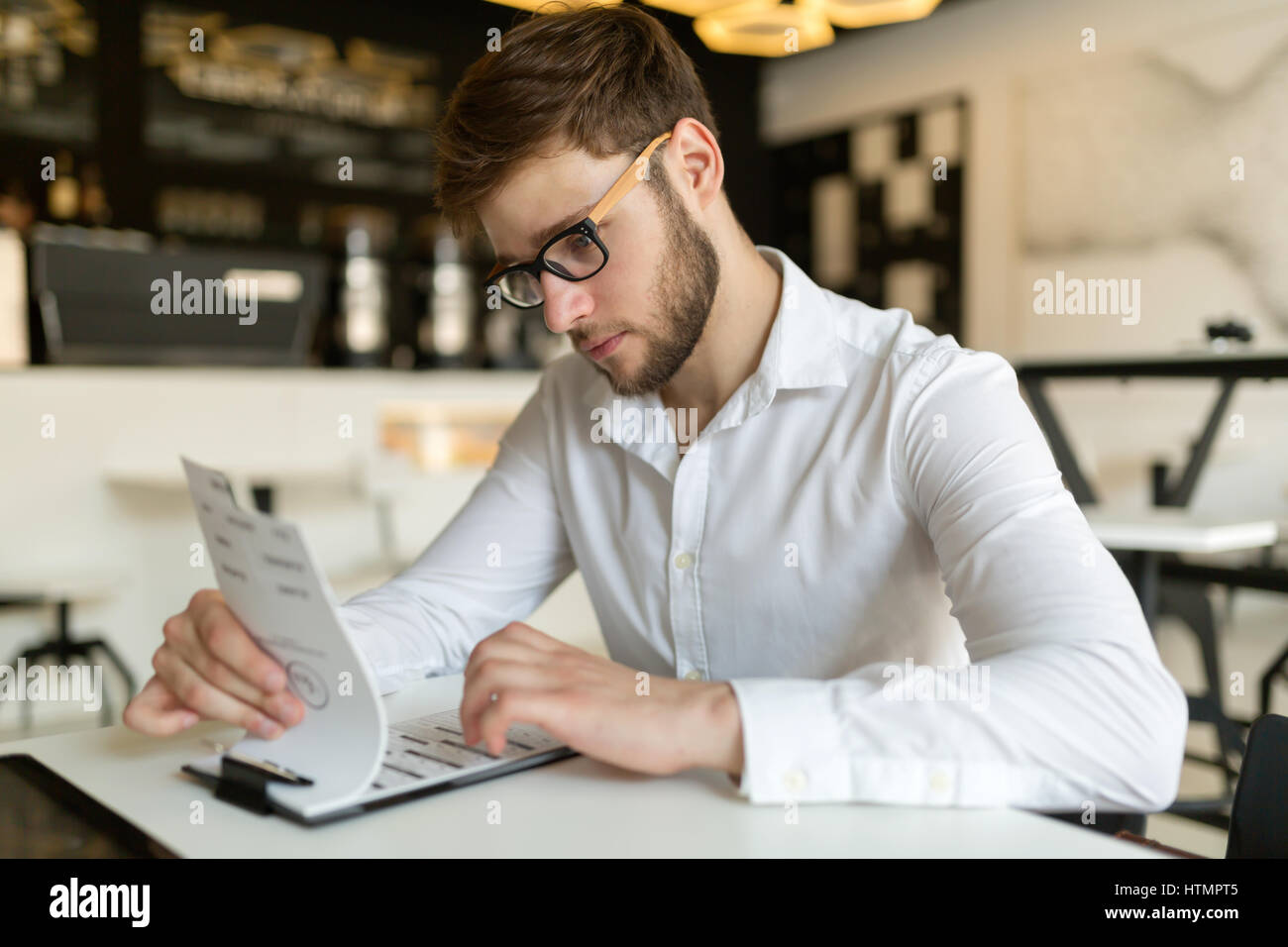 Imprenditore con gli occhiali la scelta dal menu del ristorante Foto Stock