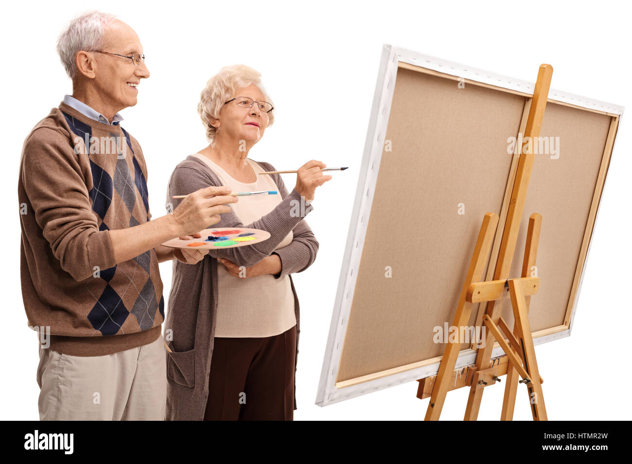 Anziani l uomo e la donna in una pittura su tela con pennelli isolati su sfondo bianco Foto Stock