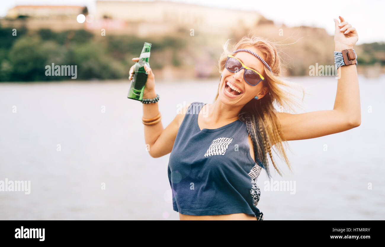 La ragazza di partito ad un festival estivo azienda bere e divertirsi Foto Stock